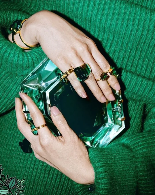 Hands styled with rings and green knitwear